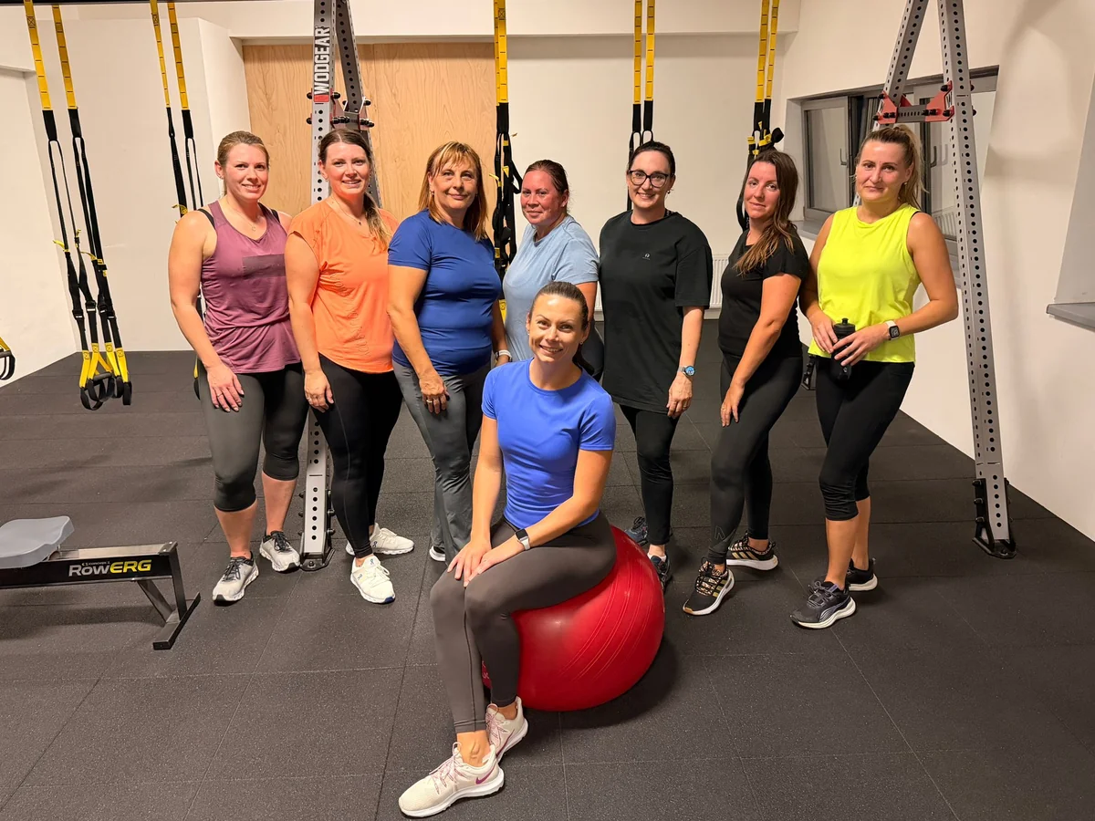 Skupina žien z programu FIT LADIES s trénerkou v telocvični